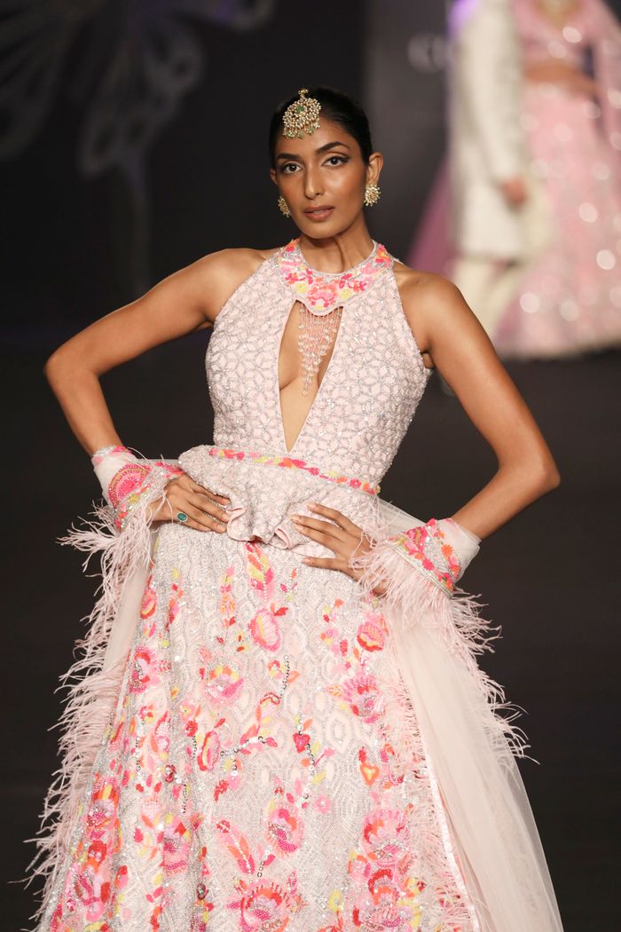 Stunning model in pink floral dress, showcasing elegance at a New Delhi fashion show.
