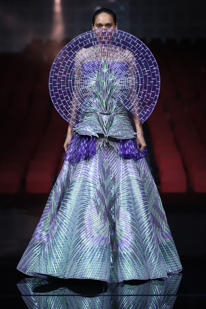 Model wearing avant-garde gown in purple at New Delhi fashion event.