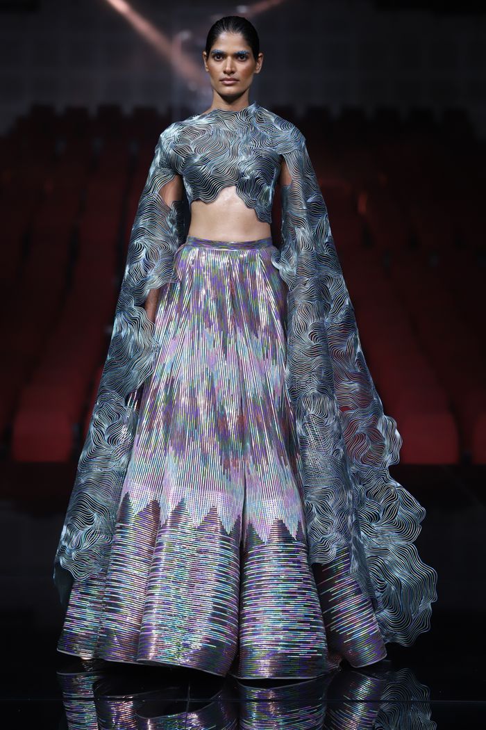 Model showcasing intricate fashion design during a runway show in New Delhi.
